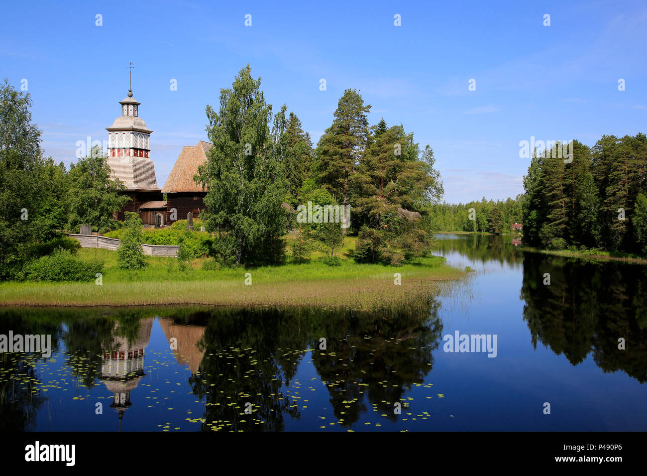 Finnische blauen See und Himmel Landschaft mit UNESCO-Weltkulturerbe, alte hölzerne Kirche von Petajavesi, Finnland im Sommer. Die Kirche wurde 1763-65 erbaut. Stockfoto