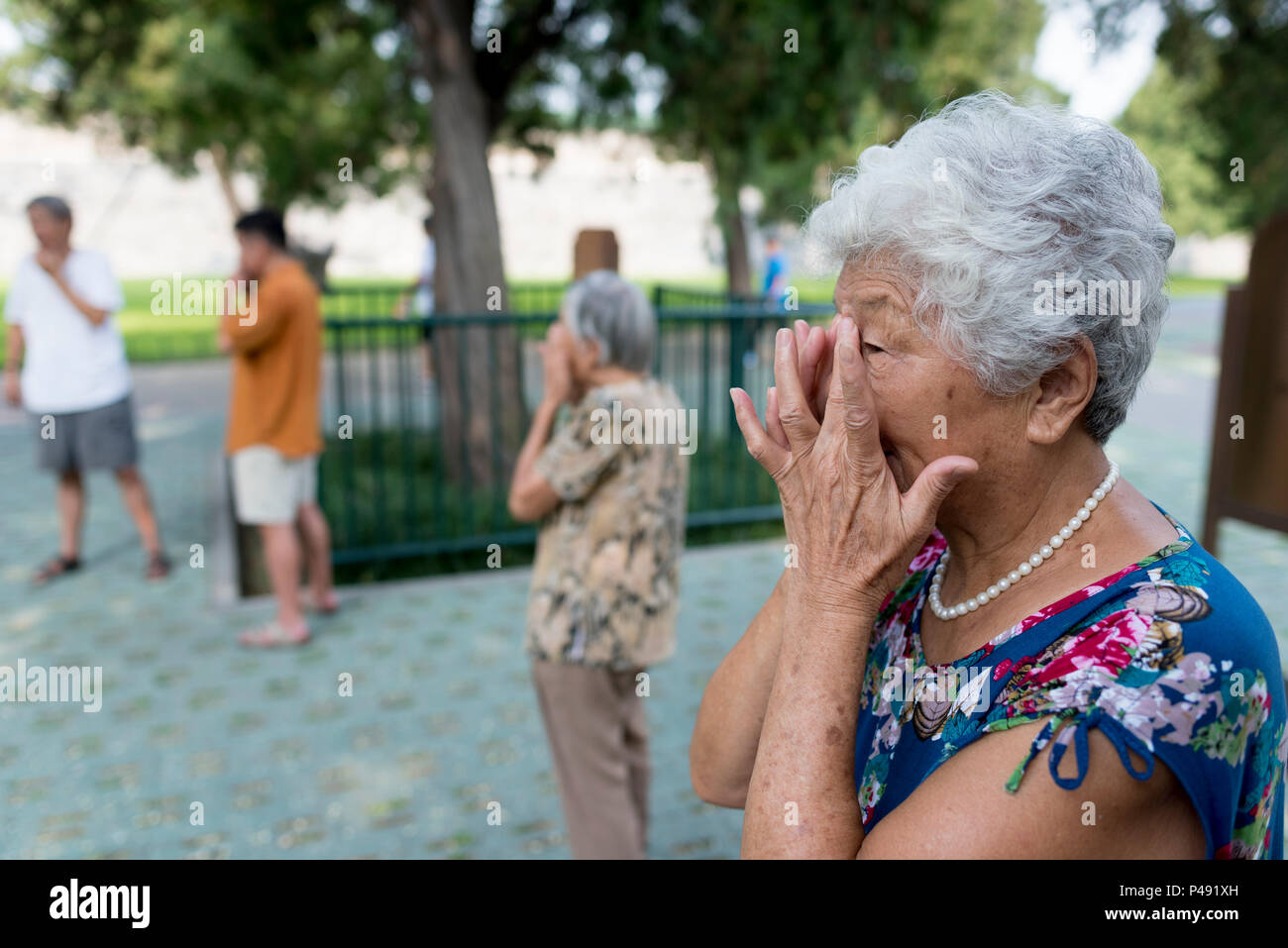 Rentner Übungen im Park rund um den Tempel des Himmels, Peking, China Gesicht Stockfoto