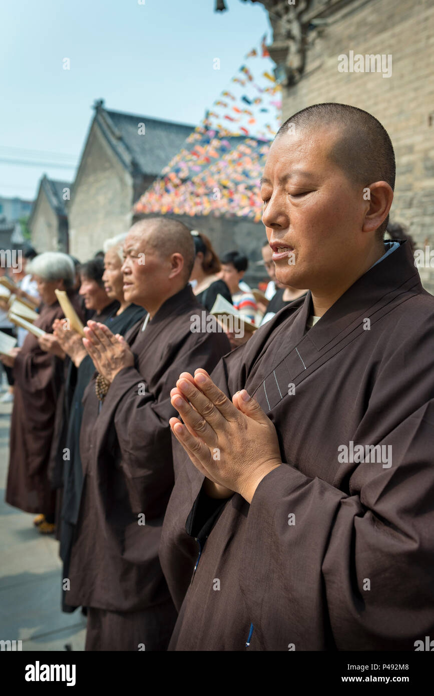 Buddhistische Nonnen beten für die jüngsten Opfer von Erdbeben außerhalb Tempel, Zibo, Provinz Shandong, China Stockfoto