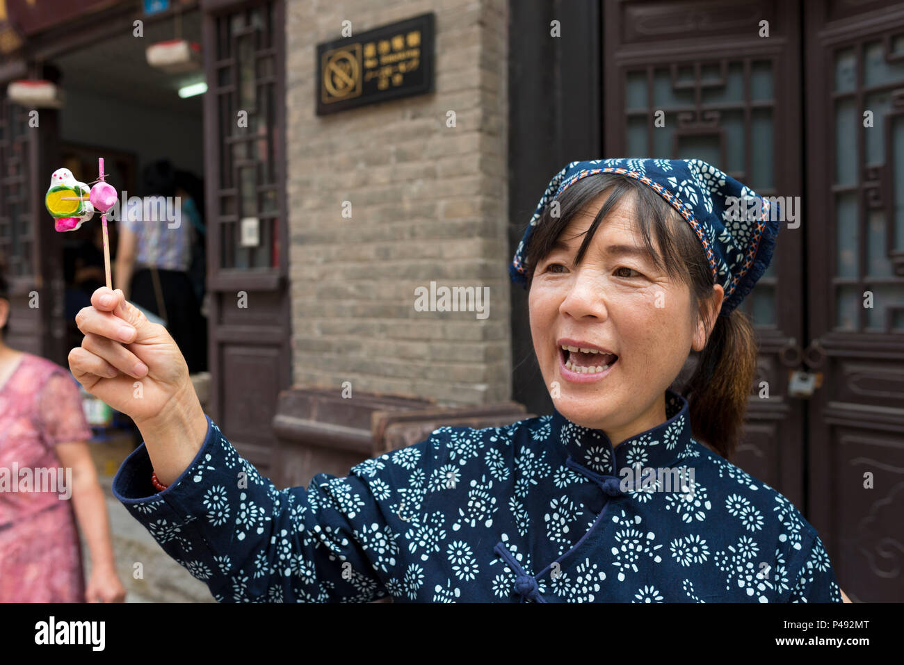 Frau schreit und Schaukeln handgemachte Spielzeug cricket Krachmacher für Verkauf, Zhoucun touristischen Bereich, ZiboZibo, Shandong Province, China Stockfoto