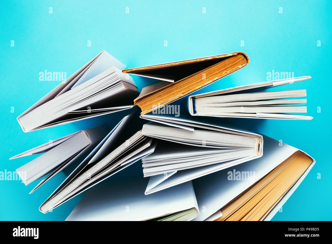 Bücher von oben auf blauem Hintergrund, Bildung und Alphabetisierung Konzept Stockfoto