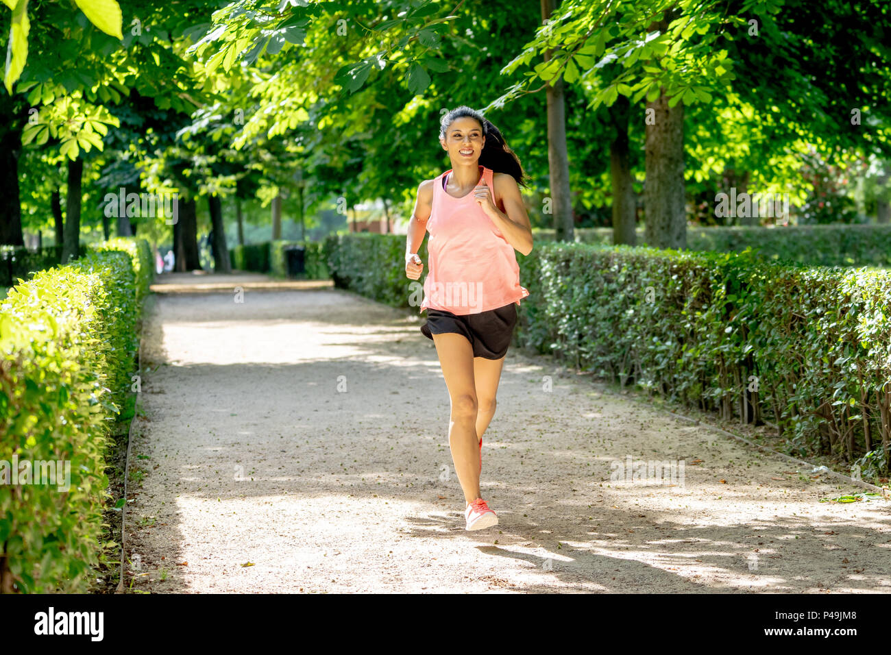 Junge attraktive und Happy runner Frau im Herbst Sportbekleidung Running und Training auf Joggen im Freien Training im City Park mit Bäumen und Gelb lassen Stockfoto