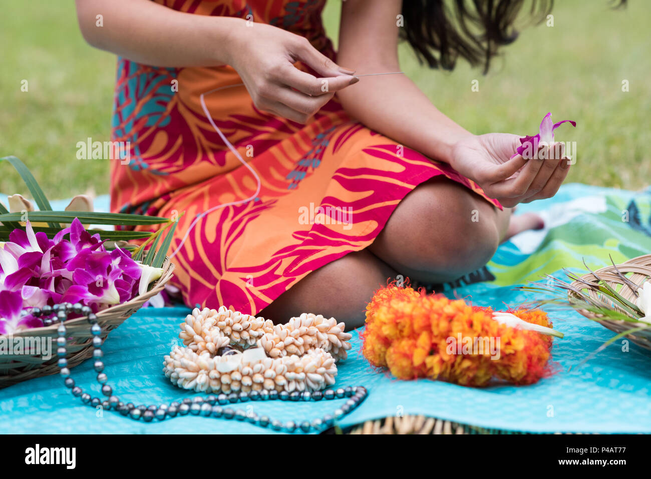 Frau Vorbereitung lei Girlande im Garten Stockfoto