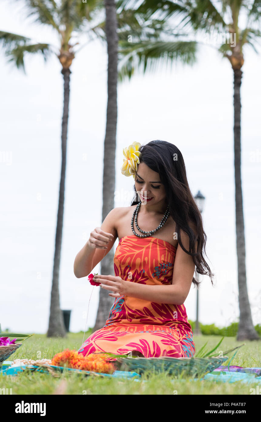 Frau Vorbereitung lei Girlande im Garten Stockfoto