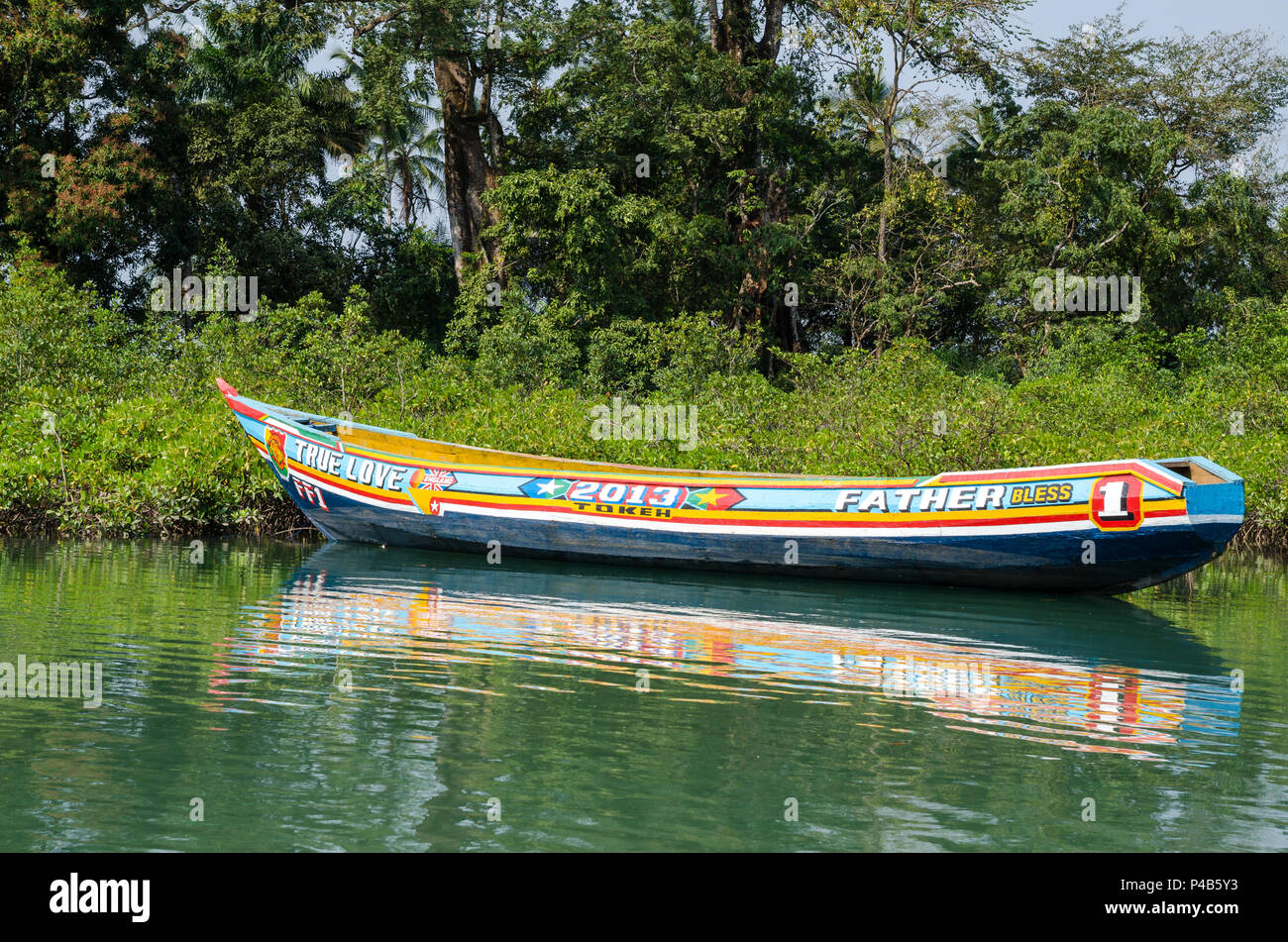 Tokeh Strand, Sierra Leone - 06 Januar, 2014: schön und bunt bemalten hölzernen Einbaum Boot in den Mangrovenwald günstig Stockfoto