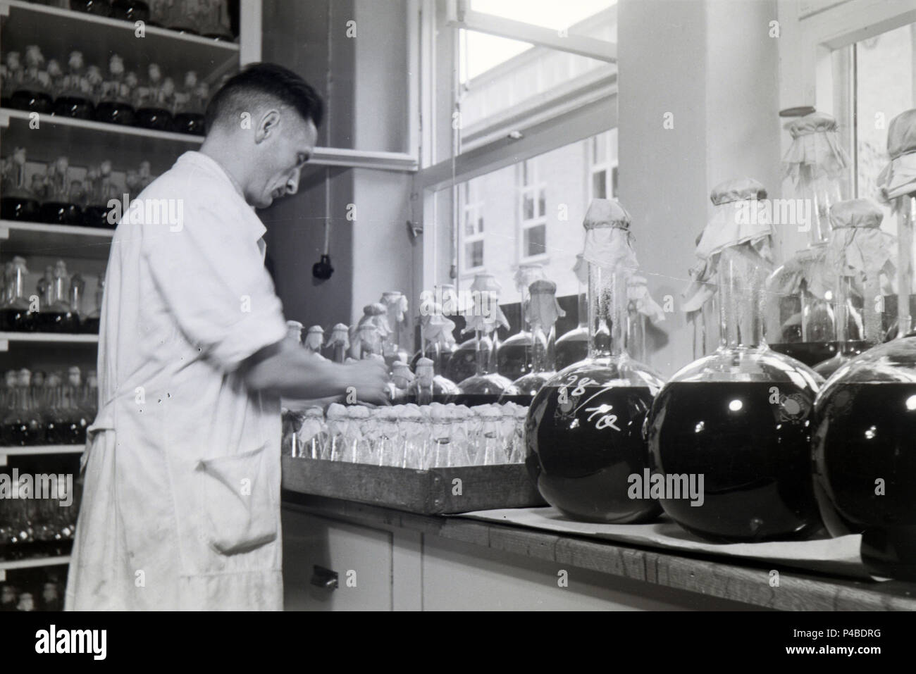 Eine Lab Assistant ist die Etikettierung der Flasche Medizin Proben in ein Labor der Behringwerke, Marburg, Deutschland 1930. Stockfoto