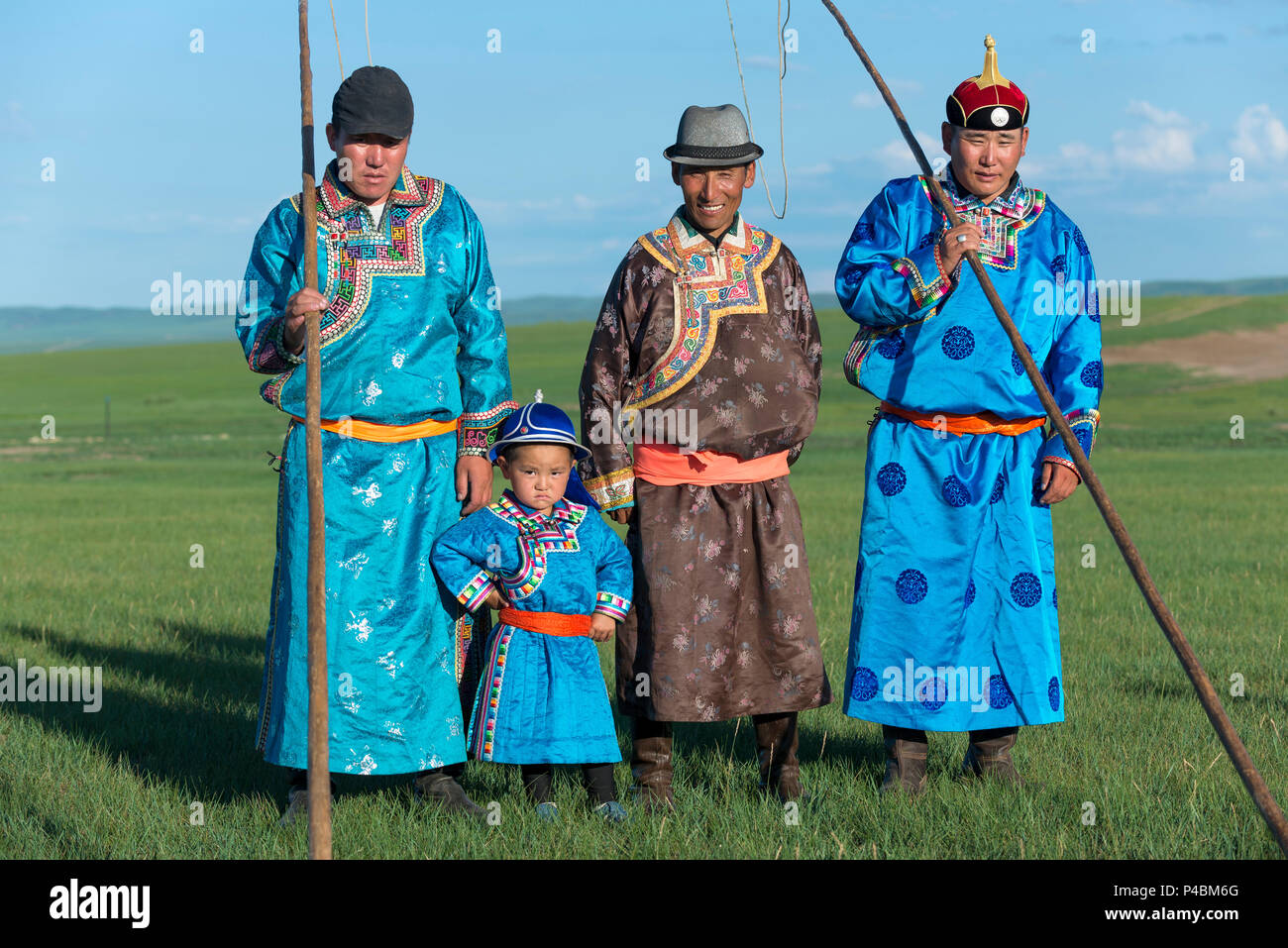 Tragen traditionelle mongolische Kleid, ein kleiner Junge steht pridefully mit älteren Familienmitgliedern, Xilinhot, der Inneren Mongolei, China Stockfoto