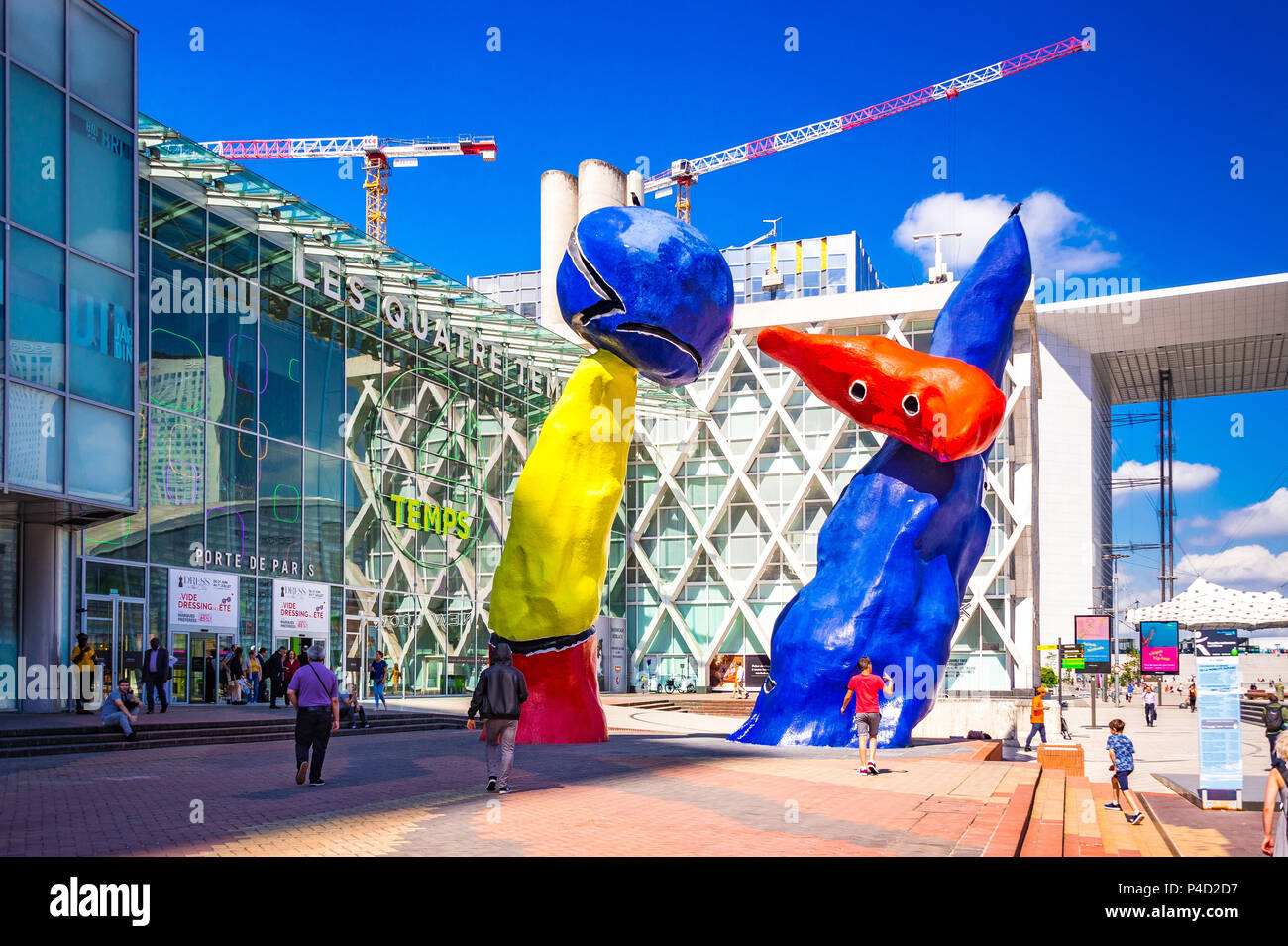 "Personnages Fantastiques' ist eine farbenfrohe Kunstwerke im Freien und zwei Tänzer, die gemeinsam spielen unter den Hochhäusern in La Défense, Paris darstellen, Stockfoto