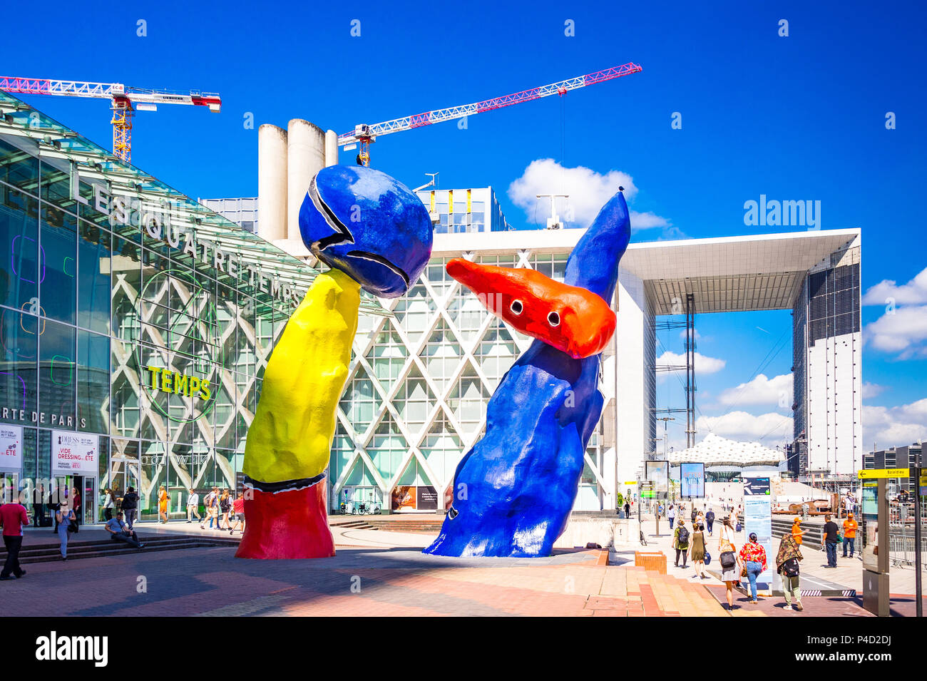 "Personnages Fantastiques' ist eine farbenfrohe Kunstwerke im Freien und zwei Tänzer, die gemeinsam spielen unter den Hochhäusern in La Défense, Paris darstellen, Stockfoto
