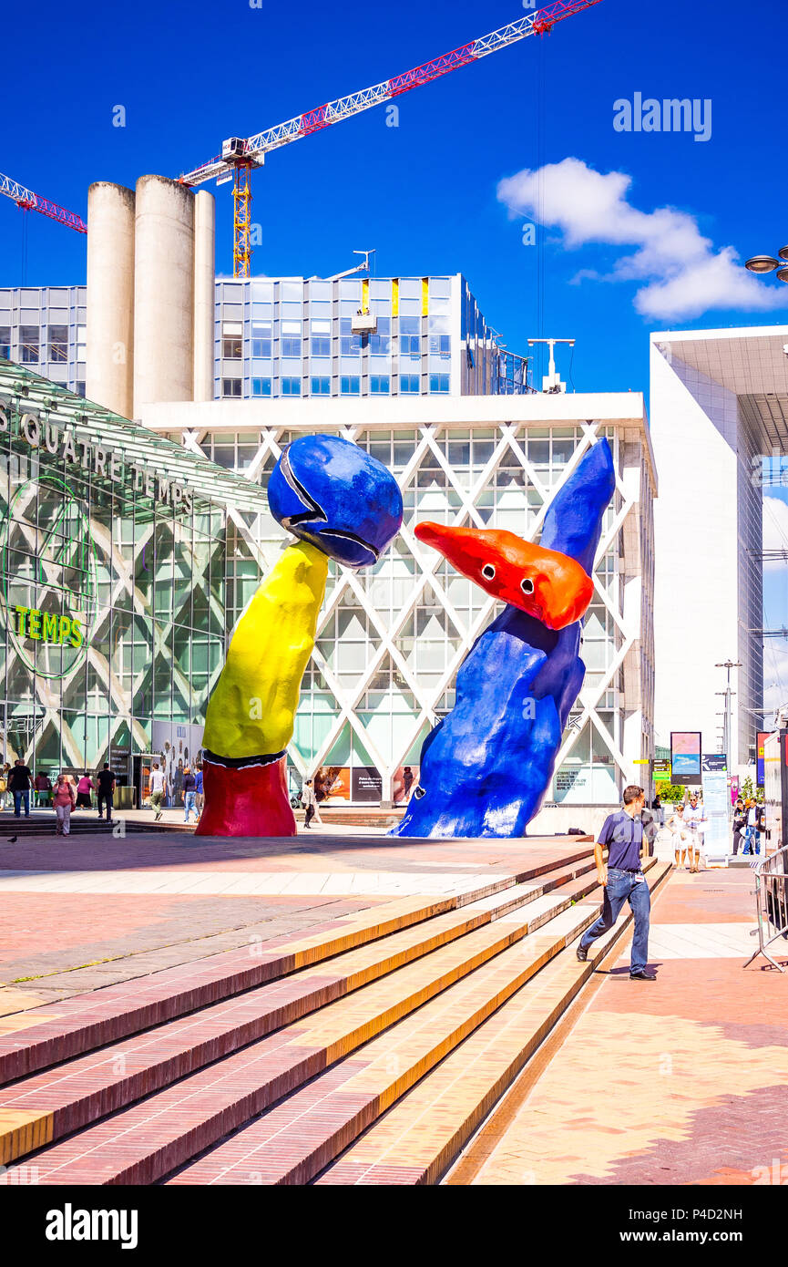 "Personnages Fantastiques' ist eine farbenfrohe Kunstwerke im Freien und zwei Tänzer, die gemeinsam spielen unter den Hochhäusern in La Défense, Paris darstellen, Stockfoto