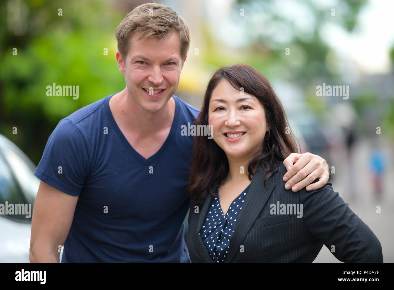 Reifen schöne asiatische Geschäftsfrau und Jungen skandinavischen Mann zusammen in den Straßen im Außenbereich Stockfoto