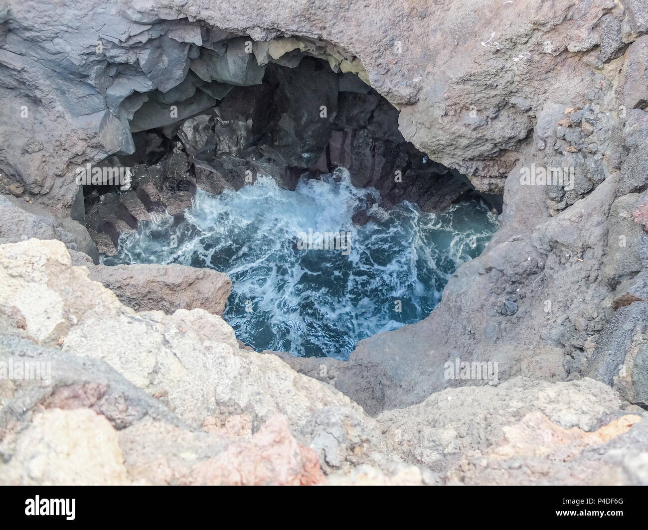 Die erodierten vulkanischen Höhlen und Klippen von Los Hervideros in Lanzarote Spanien, wo die Leute, die sich durch enge Durchgänge, die Höhlen zu sehen Stockfoto