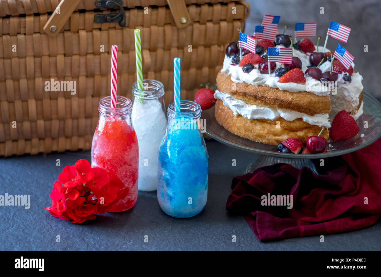 Frische Erdbeeren Angel Food Cake mit Blaubeeren, Erdbeeren, Kirschen und Sahne, und bunten Frozen Drinks mit oder ohne Alkohol. Holid Stockfoto