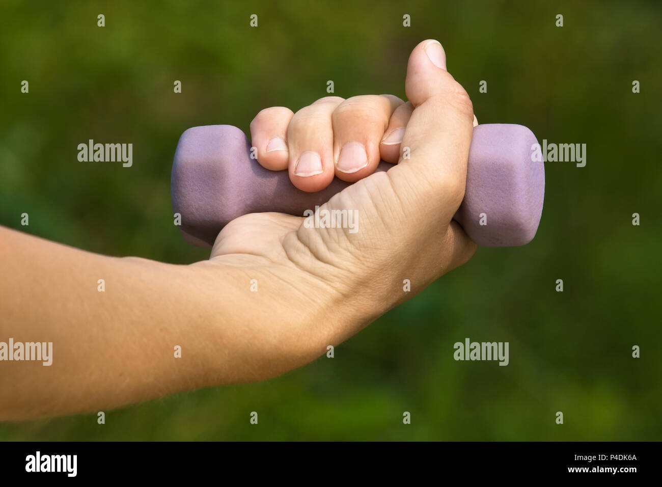 Hand Übungen mit Hantel auf Natur Hintergrund Stockfoto