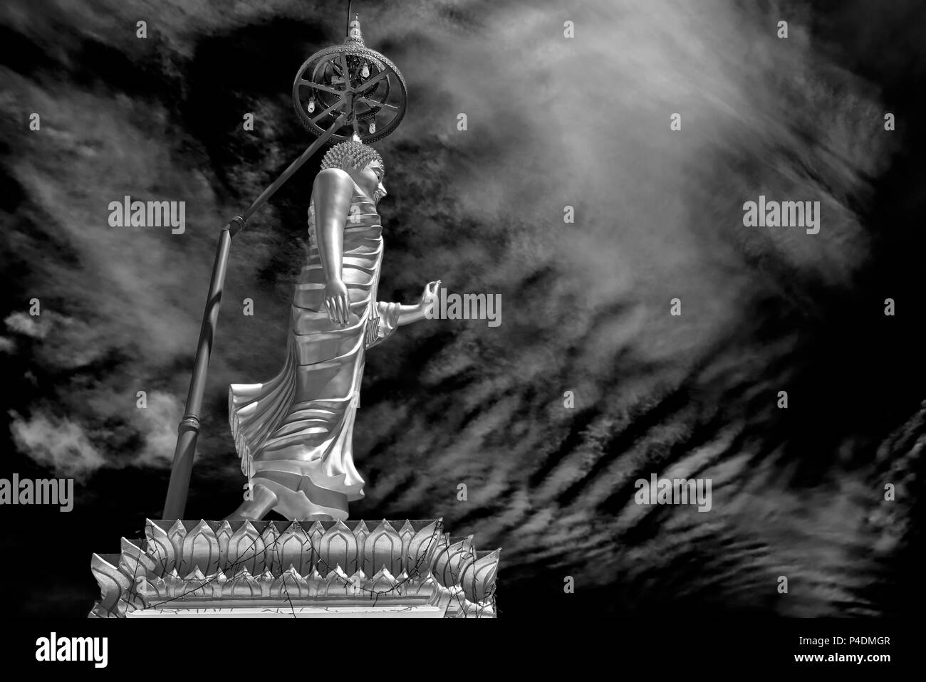 Buddha-Statue mit offener Handpalme vor einem dramatischen Himmel. Schwarzweiß-Fotografie Thailand, Südostasien Stockfoto