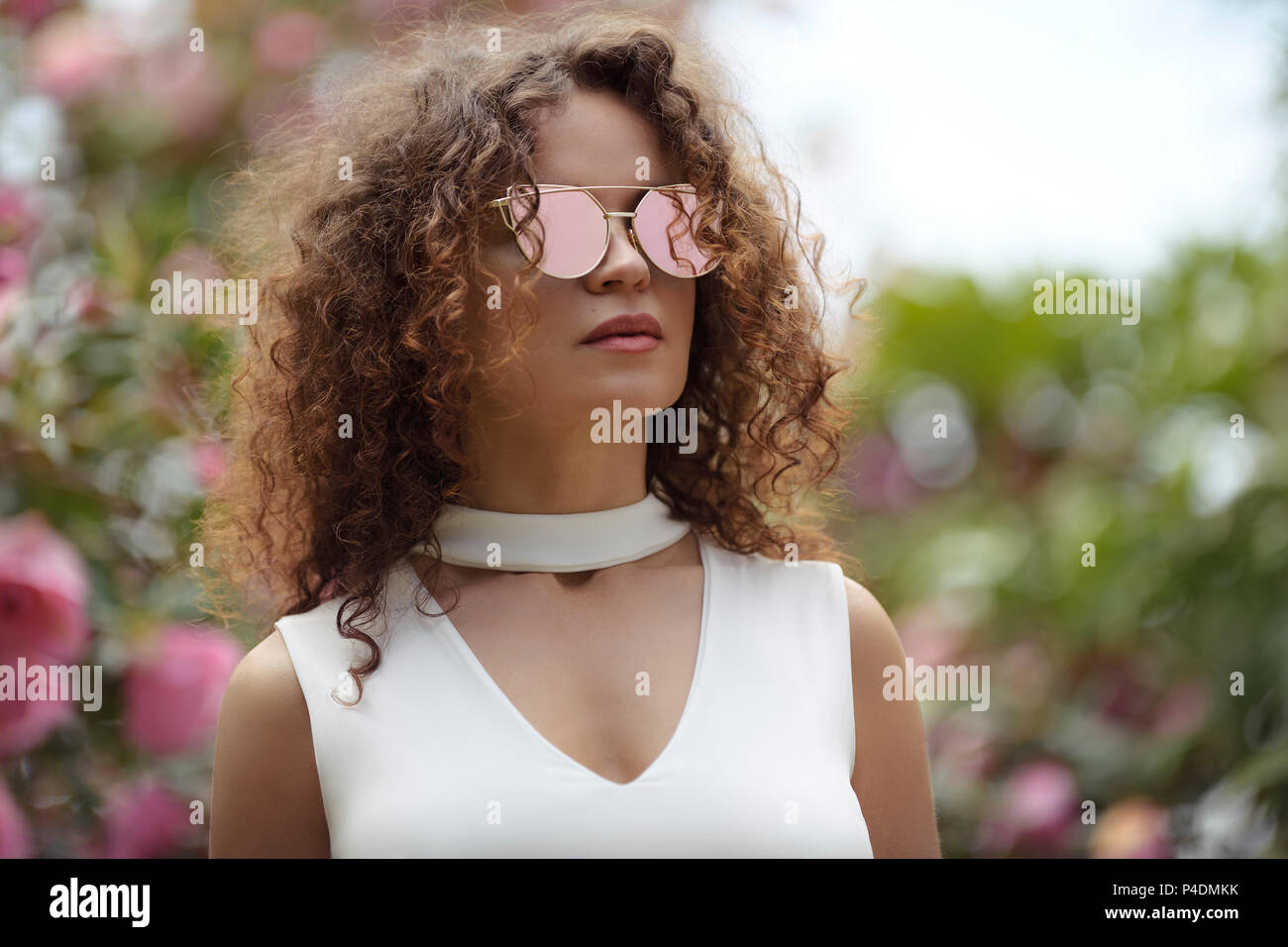 Mode Portrait einer schönen jungen stilvolle Frau mit Katze Auge geformt Spiegel Sonnenbrille und einem weißen v-ausschnitt offene Spaltung Top im Sommer sc Stockfoto