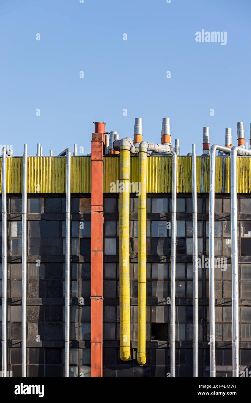 Lüftung und Leitungen der Klimaanlage auf dem Dach der industriellen Gebäude gegen den blauen Himmel Hintergrund Stockfoto