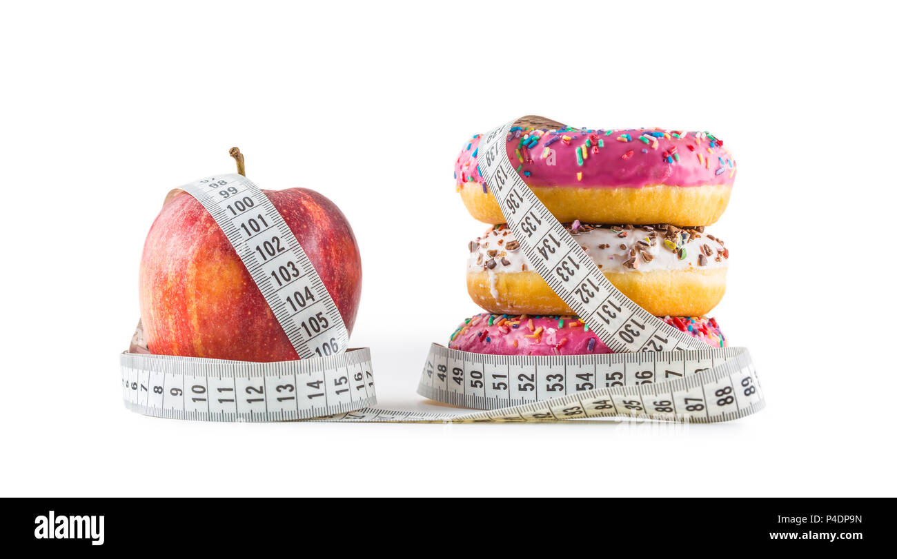 Red Apple und Drei bunte Donuts in einen Schneider Massband isoliert auf Weiß gehüllt. Stockfoto