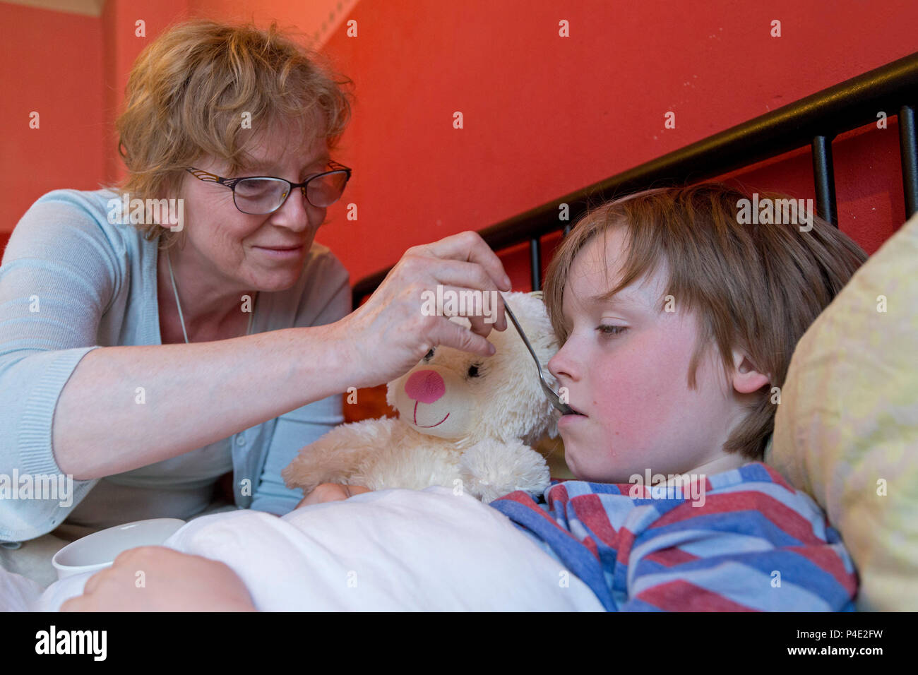 Mutter auf der Suche nach ihrem kranken Sohn in seinem Bett Stockfoto