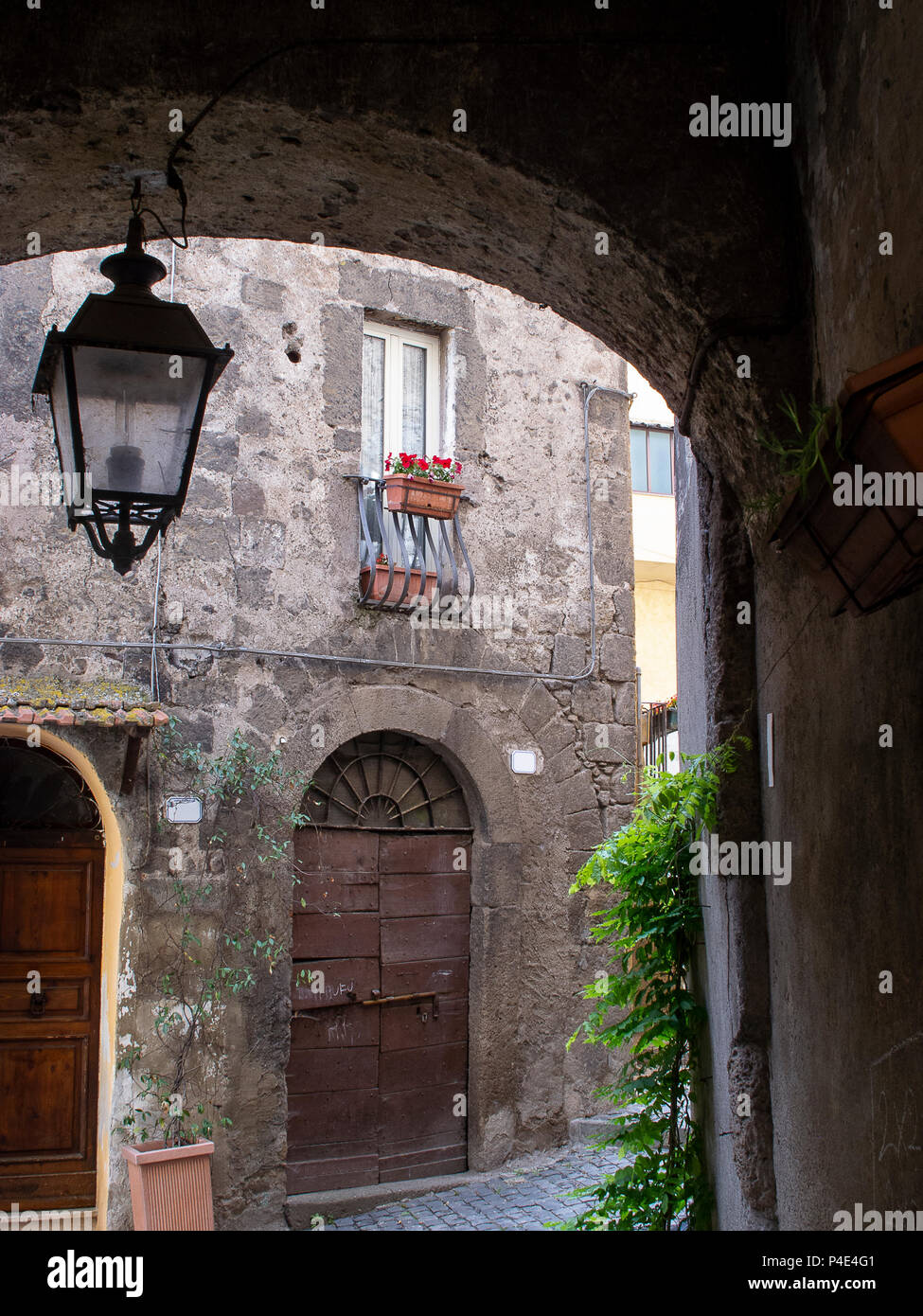 Kleine Gasse mit Bogen und hing Lamp Post, auf der Straße vor einem kleinen italienischen mittelalterliches Dorf Stockfoto