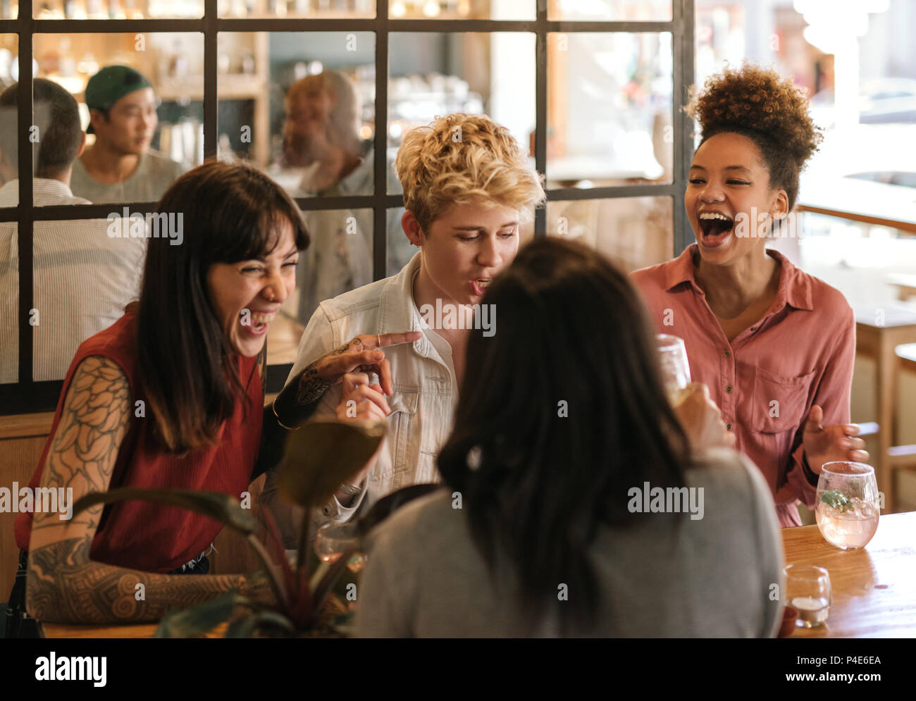 Vielfältige Gruppe von Freundinnen zusammen lachen in eine trendige Bar Stockfoto