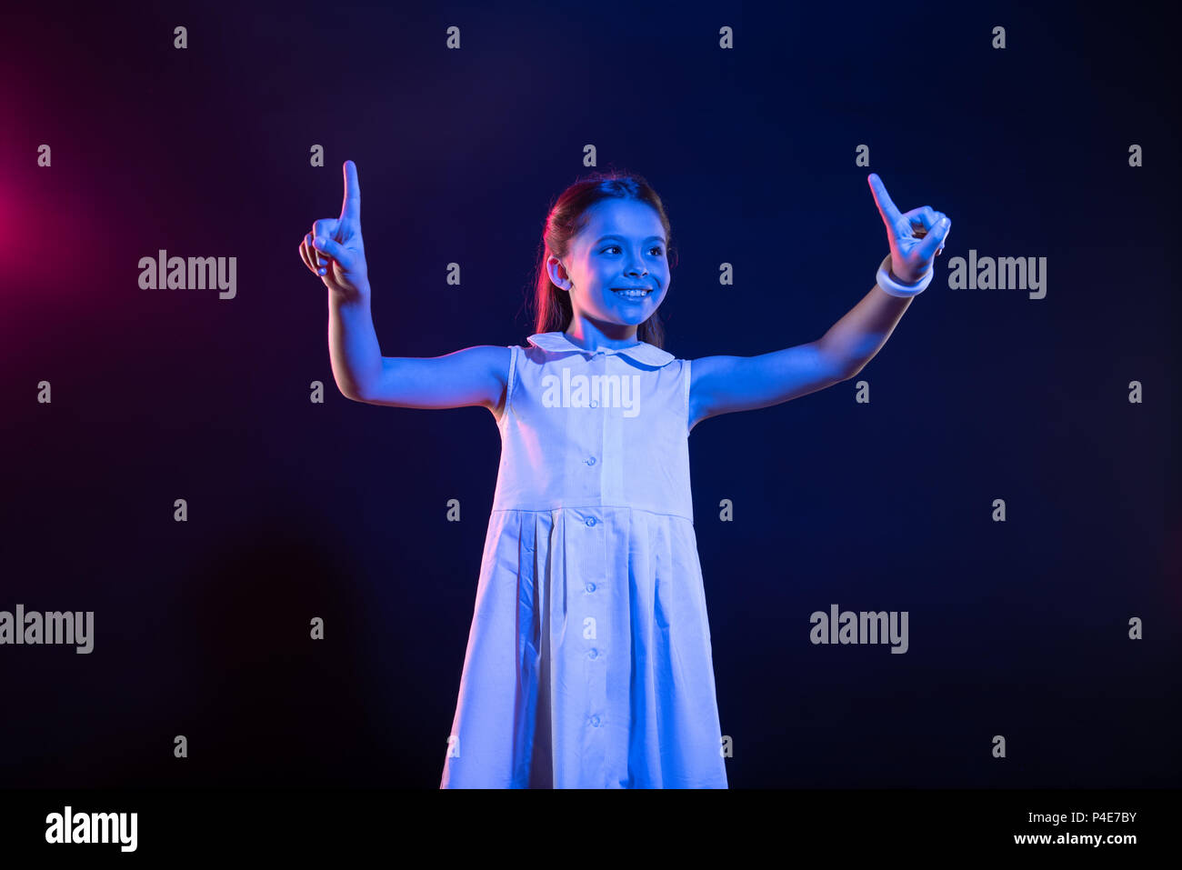 Fröhliche Schülerin imaginären Tasten drücken Stockfoto