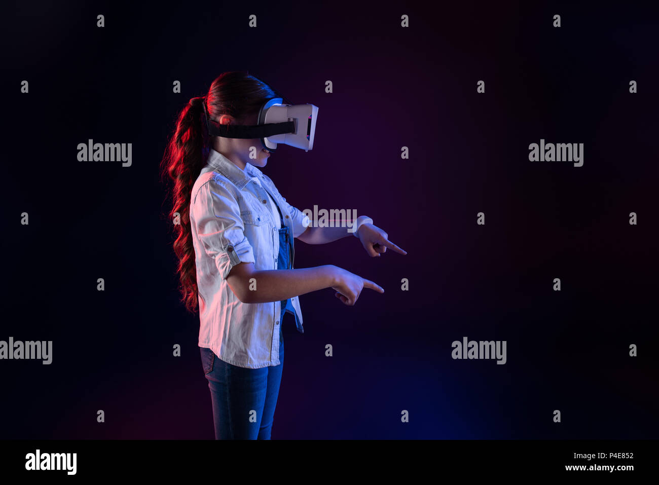 Fröhliche Schulmädchen trägt ein VR-Headset Stockfoto