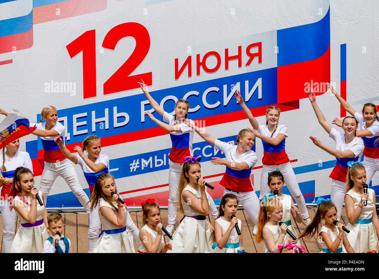 Russland, Wladiwostok, 06/12/2018. Childs in bunten Garnituren als Russische Fahne gemalt durchführen Song auf der Bühne. Feier der jährlichen Russland Tag auf Juni Stockfoto