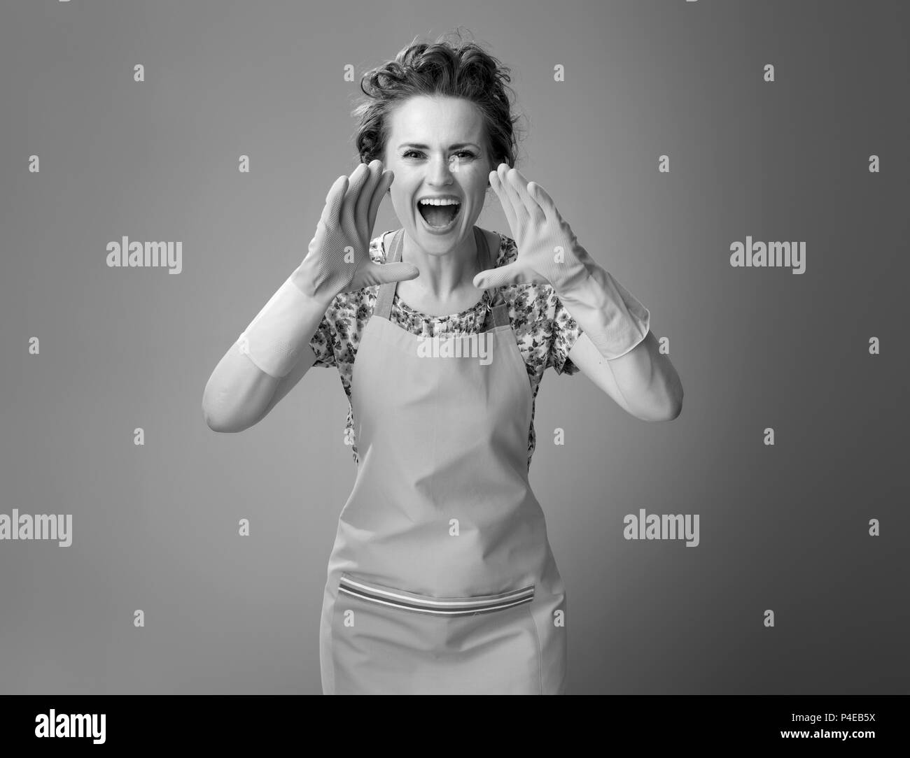 Große Reinigung Zeit. glückliche junge Frau mit gummihandschuhe Schreien über Megaphon geformten Hände isoliert auf Stockfoto
