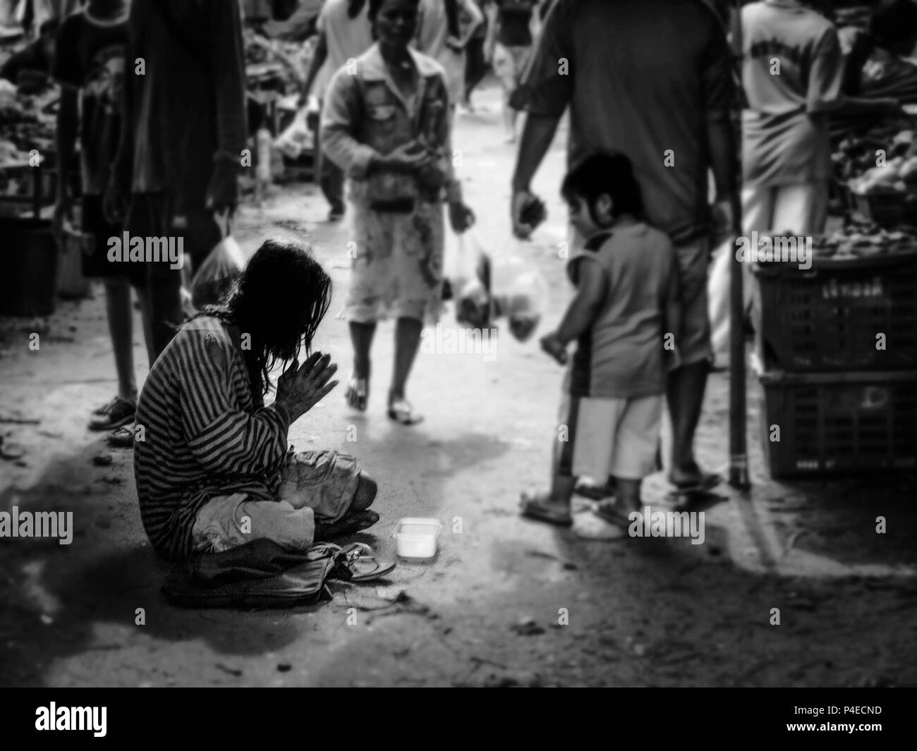 PHUKET, Thailand - 15. MÄRZ 2009: Ein alter Mann oder älteren Menschen, einen Obdachlosen seine Hand bereit für Geld, während ein Mädchen betrachten ihn in frischen Fragen heben Stockfoto