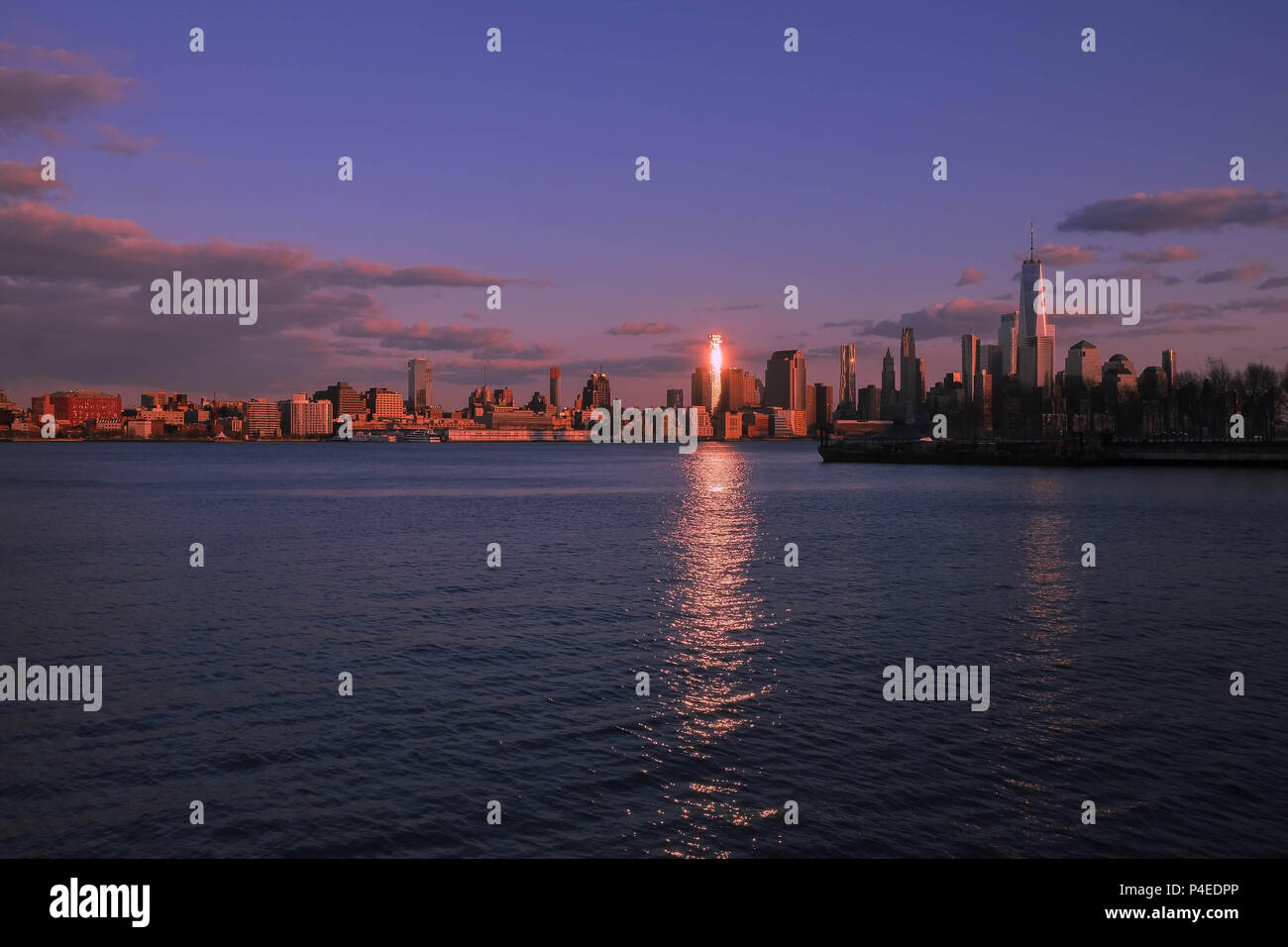 New York City Skyline von Hoboken, NJ. Während einer Feder Sonnenuntergang mit Reflexionen des Lichts über den Hudson River. Stockfoto
