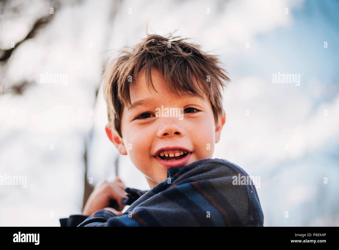 Portrait eines lächelnden jungen auf einer Schaukel Stockfoto