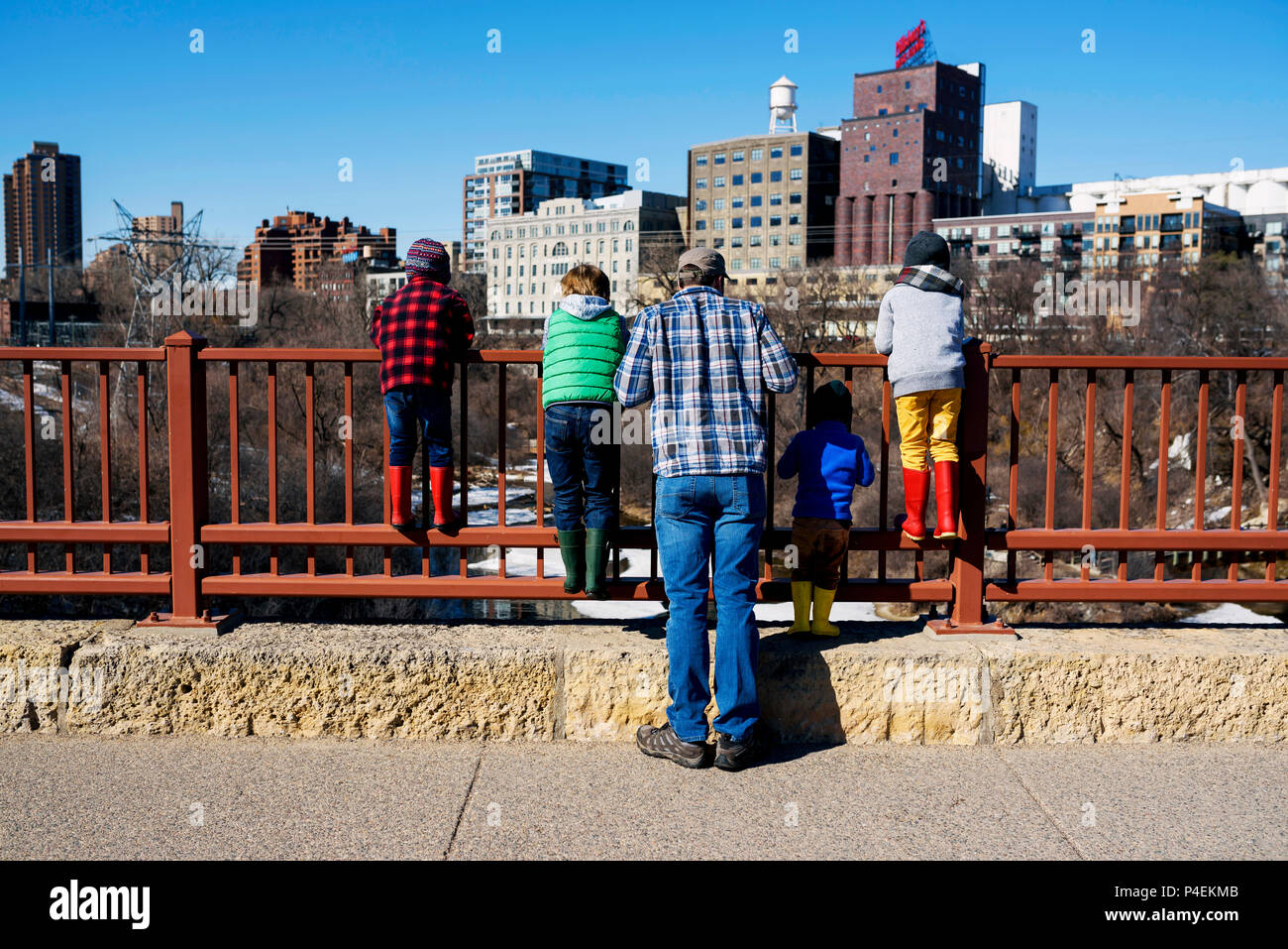 Vater stand auf Steinbogenbrücke im Stadtbild mit seinen vier Kindern, Minneapolis, Minnesota, Amerika, USA Stockfoto