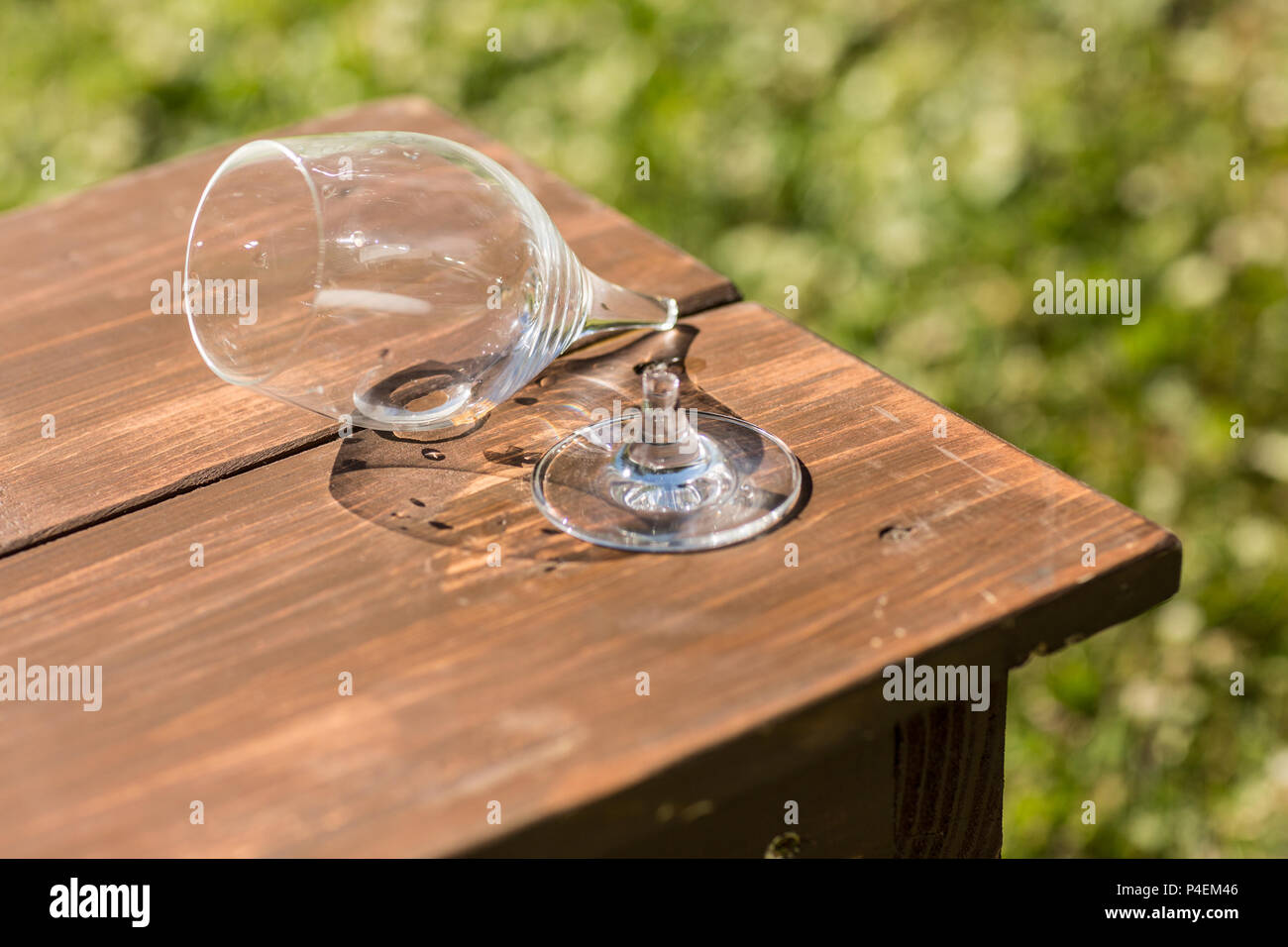 Gebrochene Glas Wein auf einer Holzbank Stockfoto