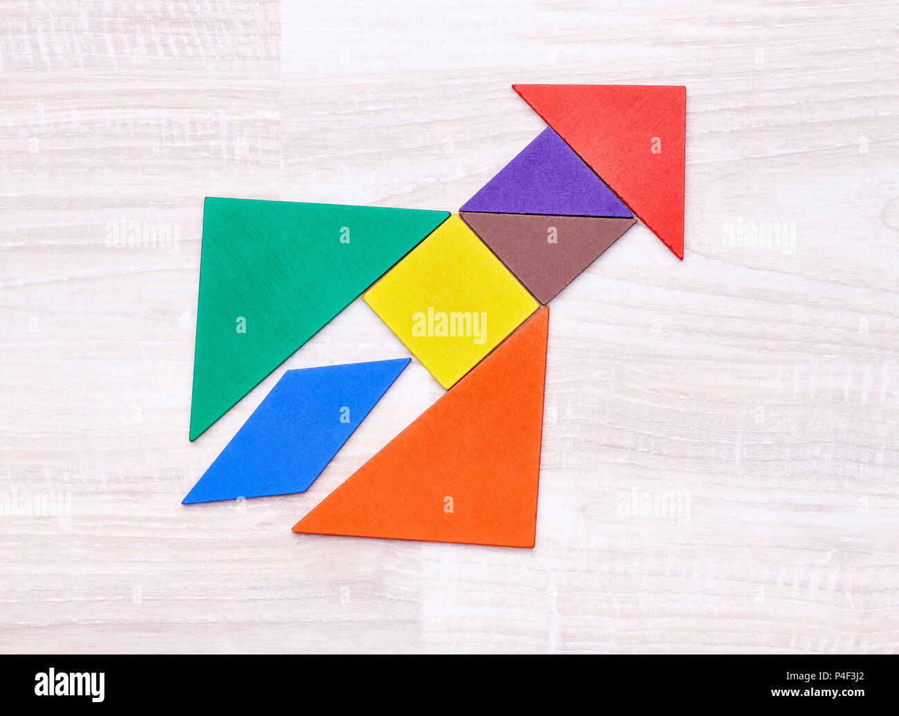 Flay lay von bunten Tangram zahlen in Form der Rakete auf hölzernen Tisch angeordnet. Stockfoto