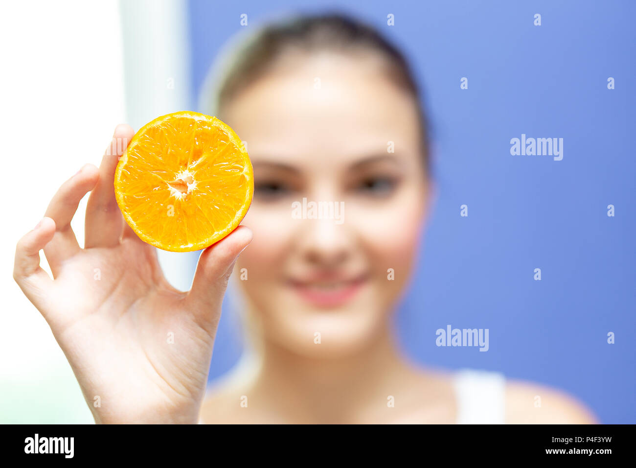 Junge Frau, Grapefruit oder Orange, und zeigen Sie auf Kamera. Gesundes Leben, Diät und Ernährung. Stockfoto