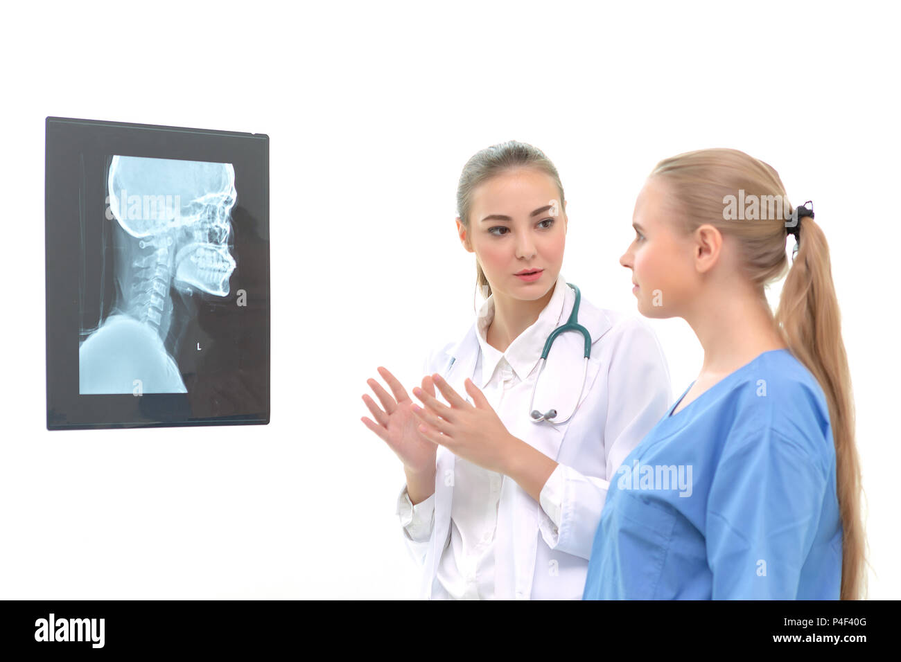 Ärzte Frauen Diskussion und Überprüfung einer magnetischen Resonanz Imaging oder x-ray film Kontrolle Schädel des menschlichen Kopfes nn Untersuchungsraum. Auf weiß Isoliert Stockfoto