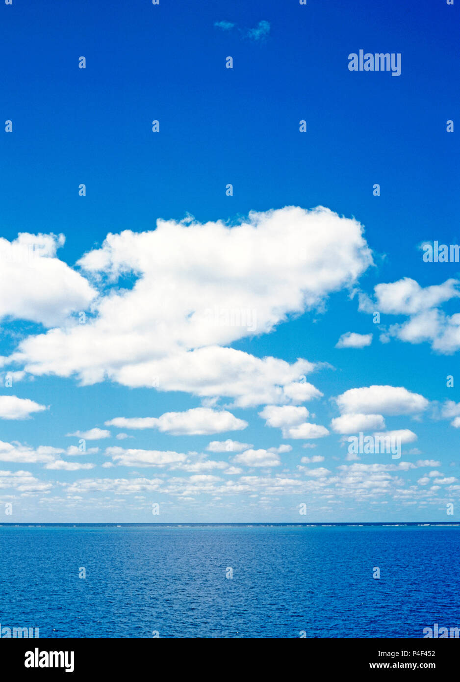 Blauer Himmel mit flauschigen weissen Wolken über dem Pazifischen Ozean Horizont des Great Barrier Reef, Queensland, Australien. Stockfoto