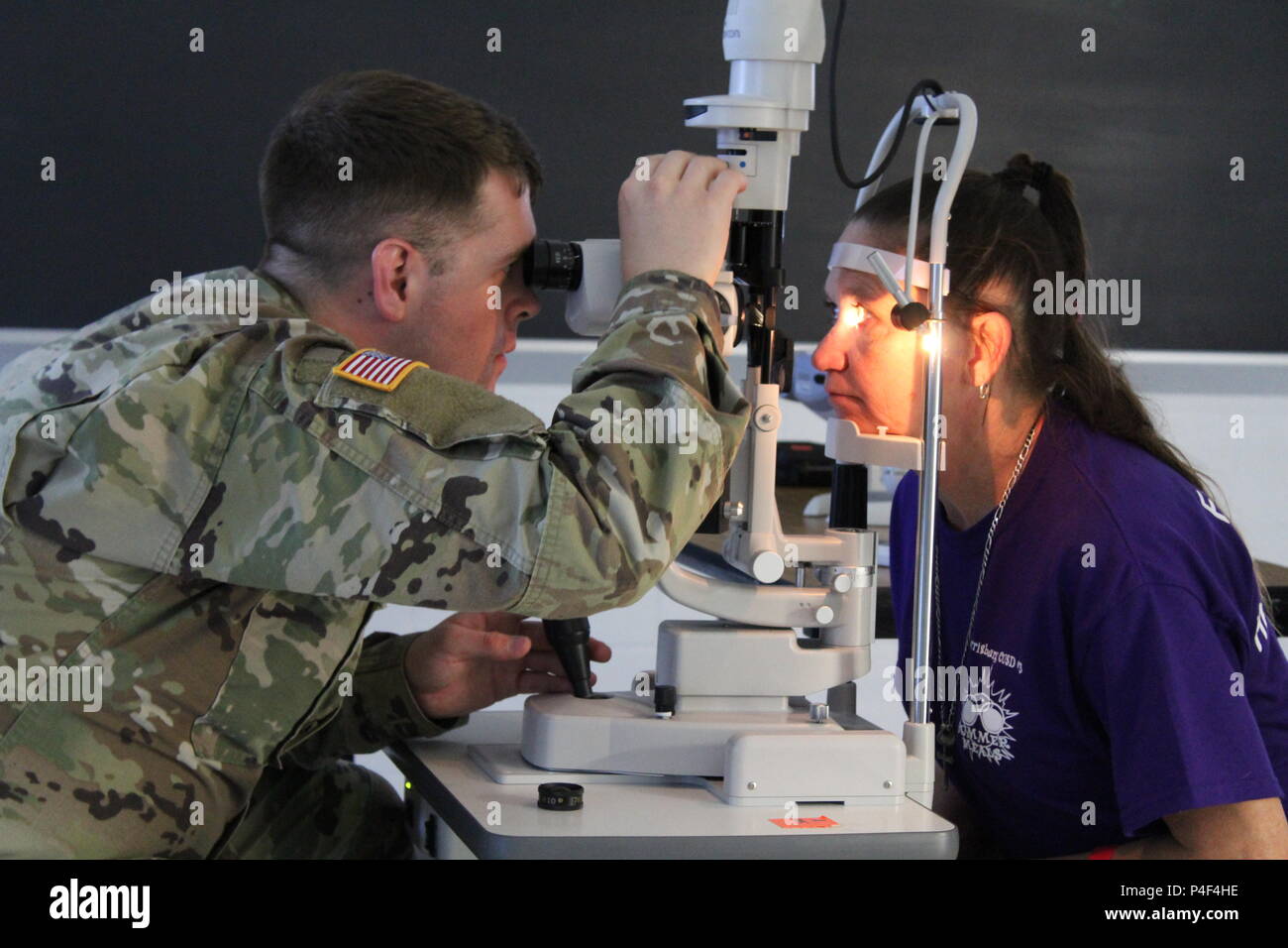 Kapitän Justin Knapp, ein Augenarzt mit der 24 medizinischen Detachment-Optometry gegründet aus Ft. Bragg, Nord-Carolina, untersucht die Augen von djuna Ryan, ein Harrisburg, Illinois Bewohner, während Innovative Readiness Training (IRT) Übung Südosten Illinois Wellness. Die IRT-Programm ist eine zivil-militärische Programm, das militärische Bereitschaft während der Bereitstellung hochwertiger Dienstleistungen im Gesundheitswesen ohne Kosten für Bewohner der südlichen Illinois zu verbessern. Foto von Maj. A. Sean Taylor, US-Armee finden Stockfoto