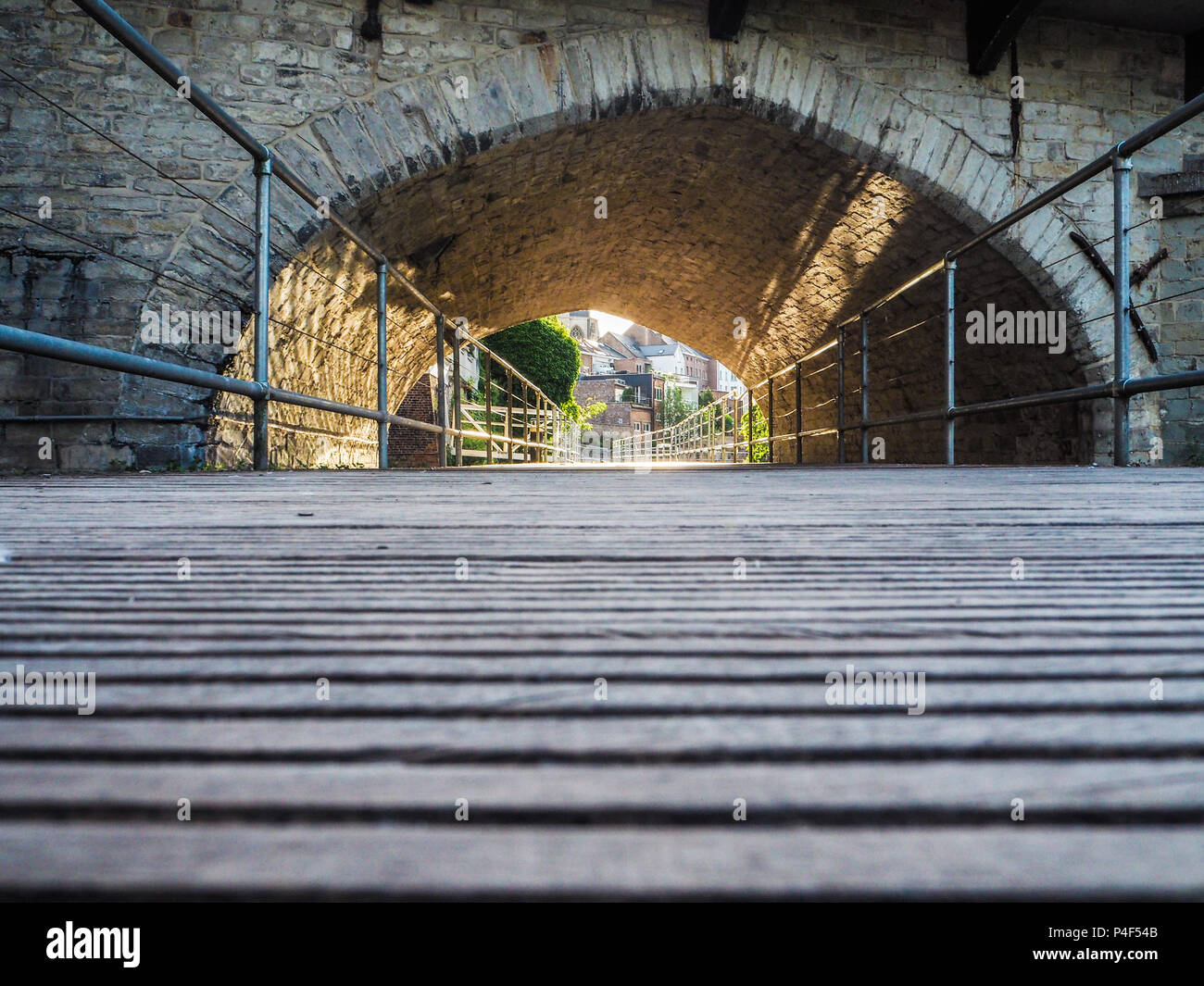 Sonnenuntergang strahlend auf dem hölzernen Pfad schlängelt sich durch die Säulen der alten gotischen Fontein Brücke über den Fluss Dyle in Mechelen, Belgien Stockfoto