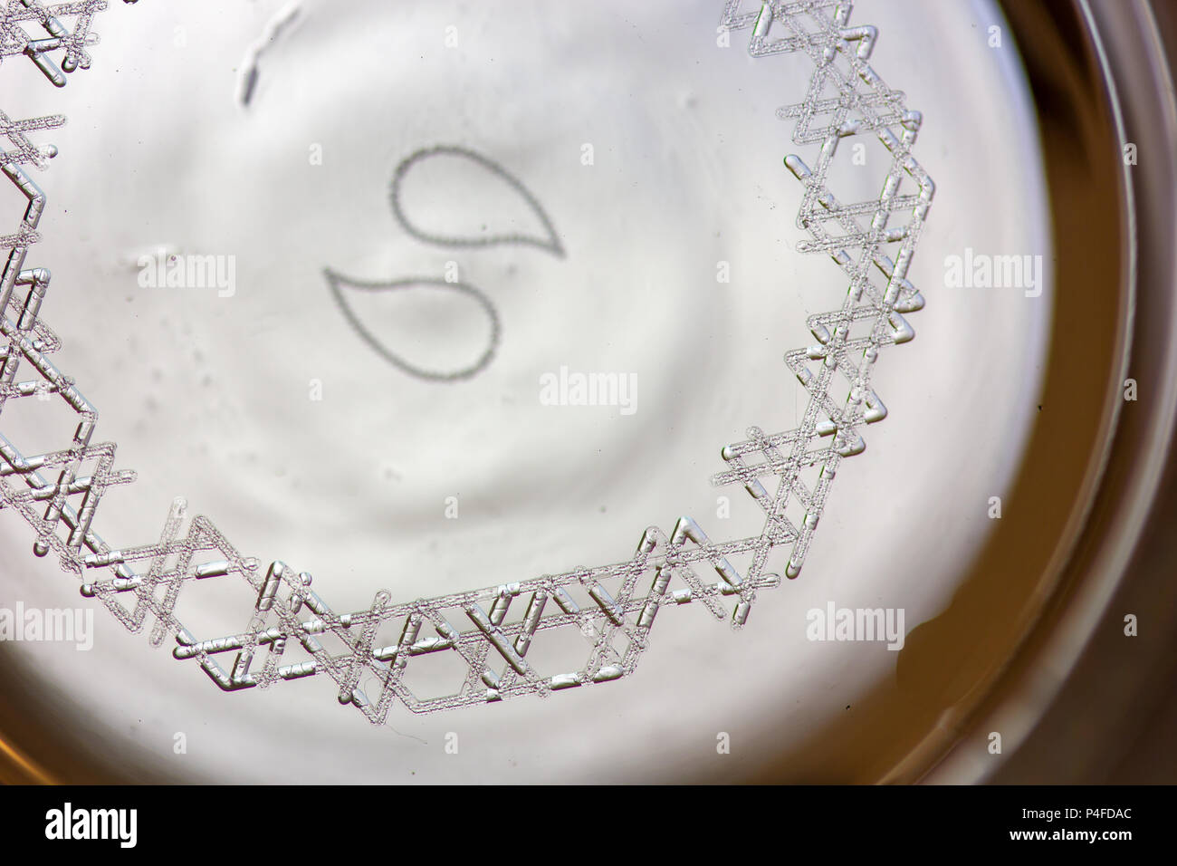 Keimbildung Markierungen graviert mit einem Laser auf der Unterseite eines Glas zu Kohlensäure von Bier zu erhöhen. Stockfoto