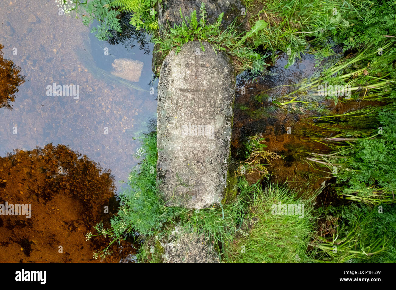 Fußgängerbrücke aus einem alten Grabstein, Kreuze über einen kleinen Bach in der Nähe von Plestin-les-Grèves, Bretagne, Frankreich. Stockfoto