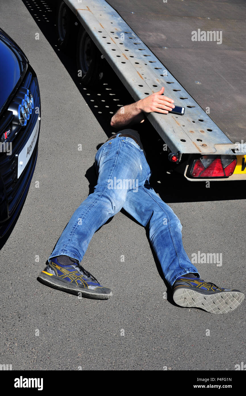 Ironisch Aufschlüsselung trailer breaksdown, Mechaniker Festlegung unter Trailer behebt das Problem Stockfoto