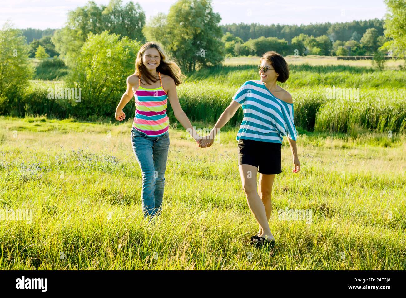 Eltern Und Teenager Gluckliche Mutter Und Jugendlich Tochter 13 14 Jahre Alt Halten Die Hande Gehen Lachen Sprechen Hintergrund Natur Park Stockfotografie Alamy