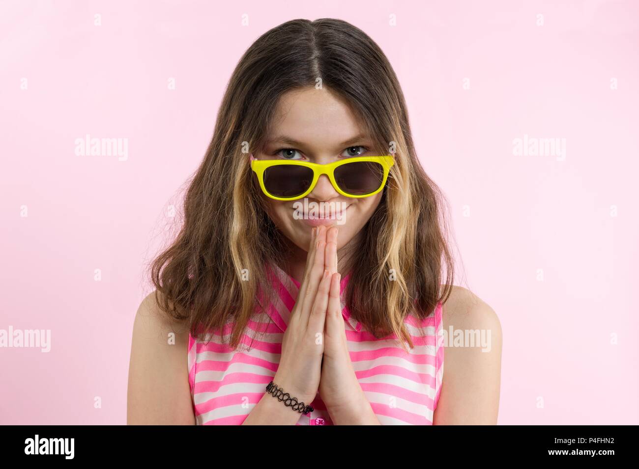 Junges Mädchen, ein Gebet, meditiert. Rosa Hintergrund Stockfoto