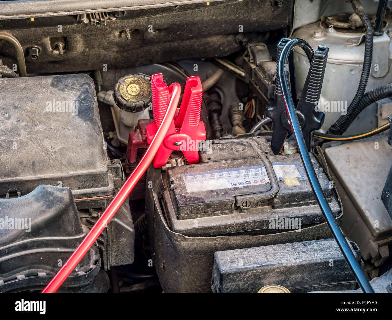 Auto Batterie wird mit zwei Überbrückungskabel an die Klemmen abgeschnitten  aufgeladen Stockfotografie - Alamy