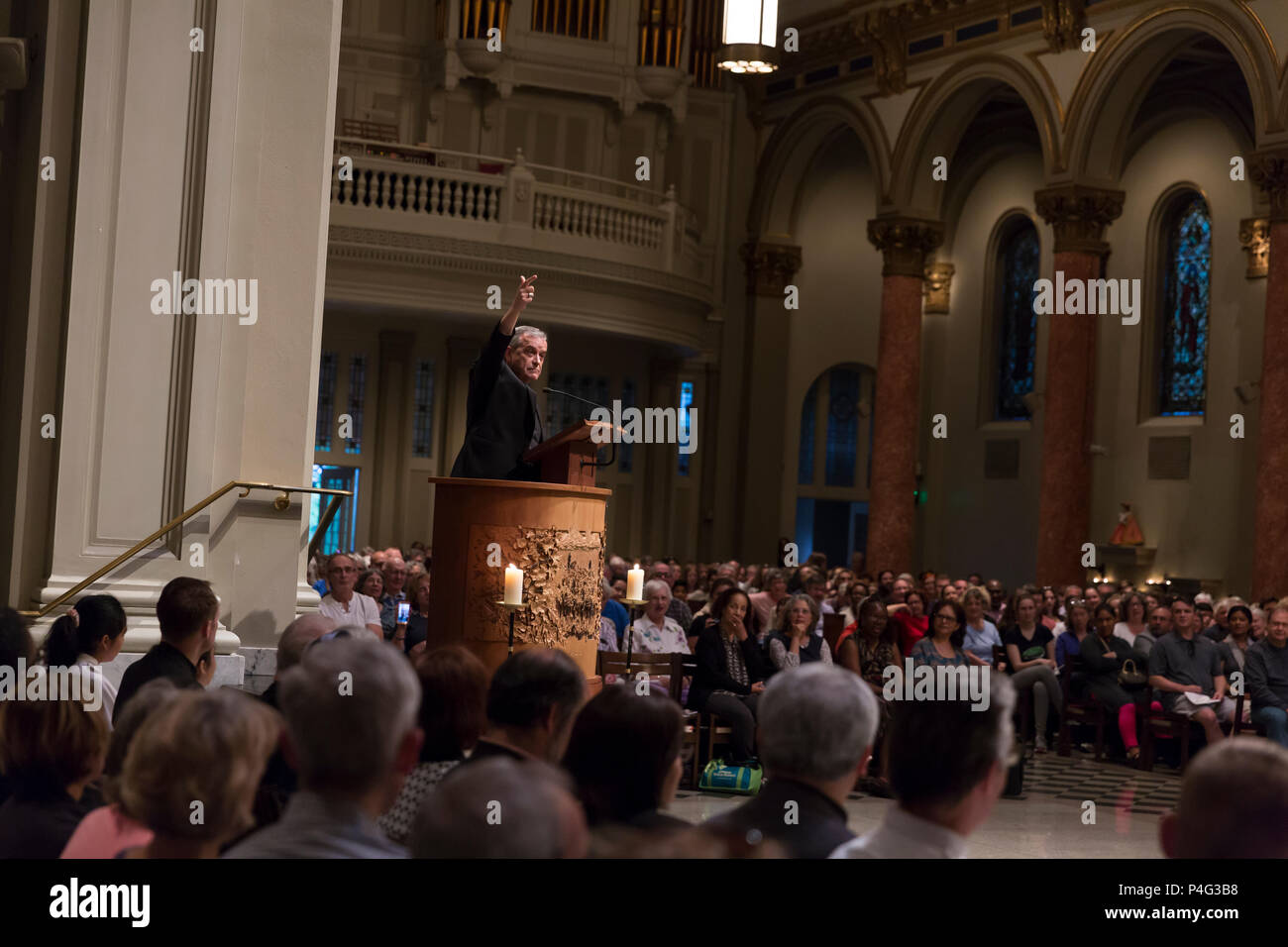 Seattle, USA. 21. Juni 2018. Ein Mitglied des Klerus Adressen Verfechter am St. James Cathedral. Hunderte von Anhängern in der St. Mark's Episcopal Cathedral in Capitol Hill für einen interreligiösen Gebet und Mahnwache in Unterstützung von Migranten und Asylbewerbern gesammelten Asylbewerber, die in die USA kommen und die unmenschliche Trennung der Kinder von ihren Eltern zu protestieren. Die beiden Meile" Gebet und Prozession für Familien an der Grenze' begann in Saint Mark's Episcopal Cathedral in endete am St. James Römisch-katholische Kathedrale in der ersten Hügel. Credit: Paul Christian Gordon/Alamy leben Nachrichten Stockfoto