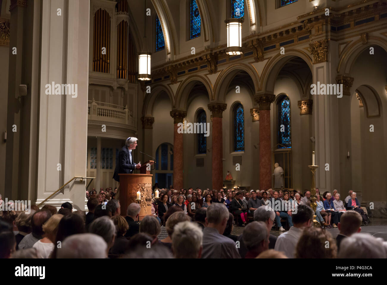 Seattle, USA. 21. Juni 2018. Ein Mitglied des Klerus Adressen Verfechter am St. James Cathedral. Hunderte von Anhängern in der St. Mark's Episcopal Cathedral in Capitol Hill für einen interreligiösen Gebet und Mahnwache in Unterstützung von Migranten und Asylbewerbern gesammelten Asylbewerber, die in die USA kommen und die unmenschliche Trennung der Kinder von ihren Eltern zu protestieren. Die beiden Meile" Gebet und Prozession für Familien an der Grenze' begann in Saint Mark's Episcopal Cathedral in endete am St. James Römisch-katholische Kathedrale in der ersten Hügel. Credit: Paul Christian Gordon/Alamy leben Nachrichten Stockfoto