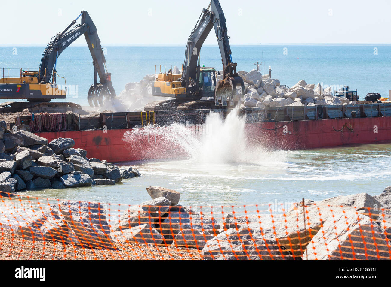 Hastings, East Sussex, Großbritannien. Juni 2018. Der Bau von zwei neuen Wellenbrecher-Felsgroyns an der Küste ist im Gange, um den Strand an seinem Platz zu halten und die Meeresmauer zu schützen. Der Auftrag für die Arbeiten wurde von J. T. Mackley Ltd, einem erfahrenen Bauunternehmer an der Küste, gewonnen. 5,000 Tonnen norwegisches Granitgestein werden auf dem Seeweg geliefert, es wird erwartet, dass die Arbeiten je nach Wetterlage 10 Wochen dauern werden. © Paul Lawrenson 2018, Bildnachweis: Paul Lawrenson / Alamy Live News Stockfoto