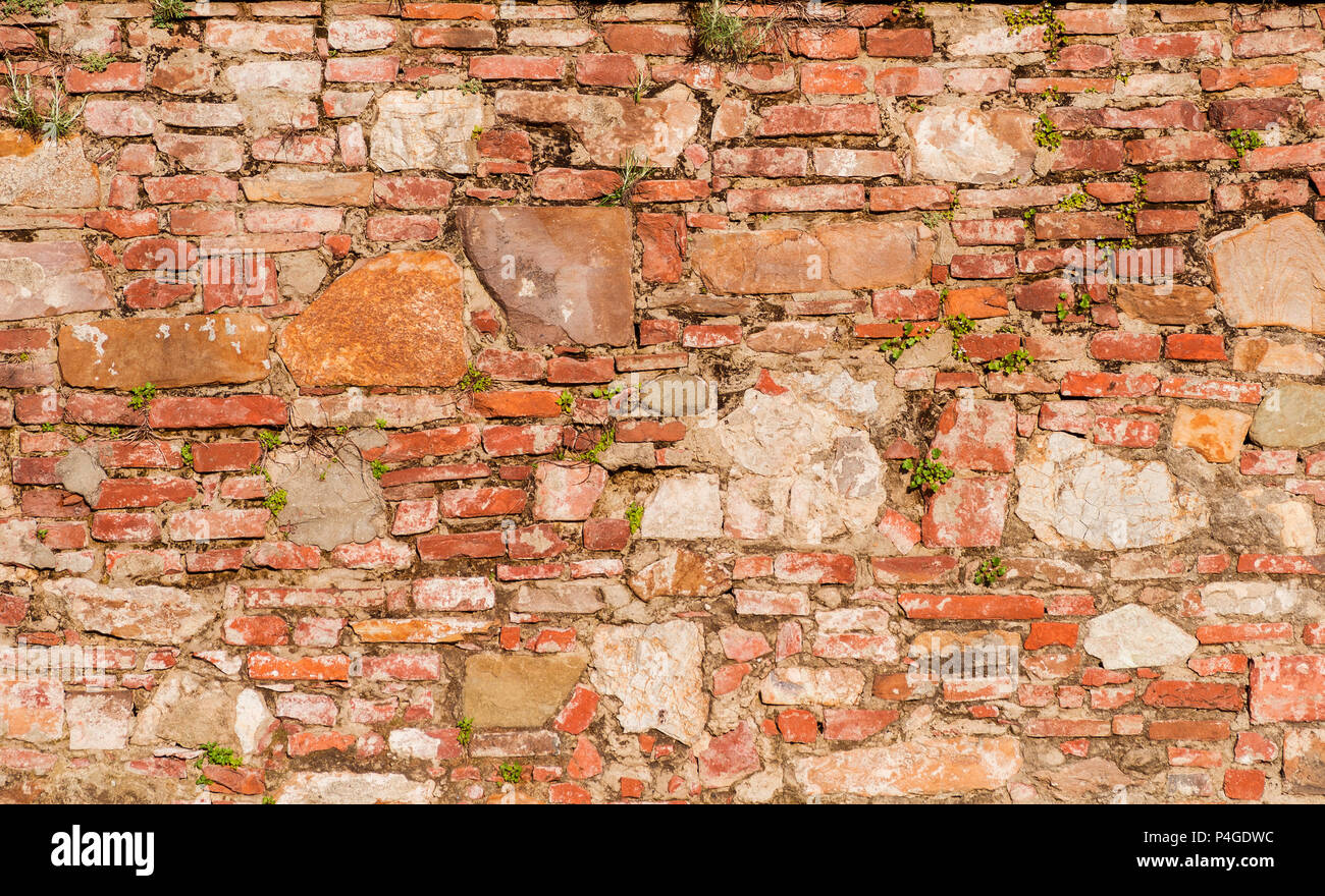 Alte Mauer mit Ziegel, Steine und Pflanzen als Hintergrund Stockfoto Alte Mauer mit Ziegel, Steine und Pflanzen als Hintergrund Stockfoto